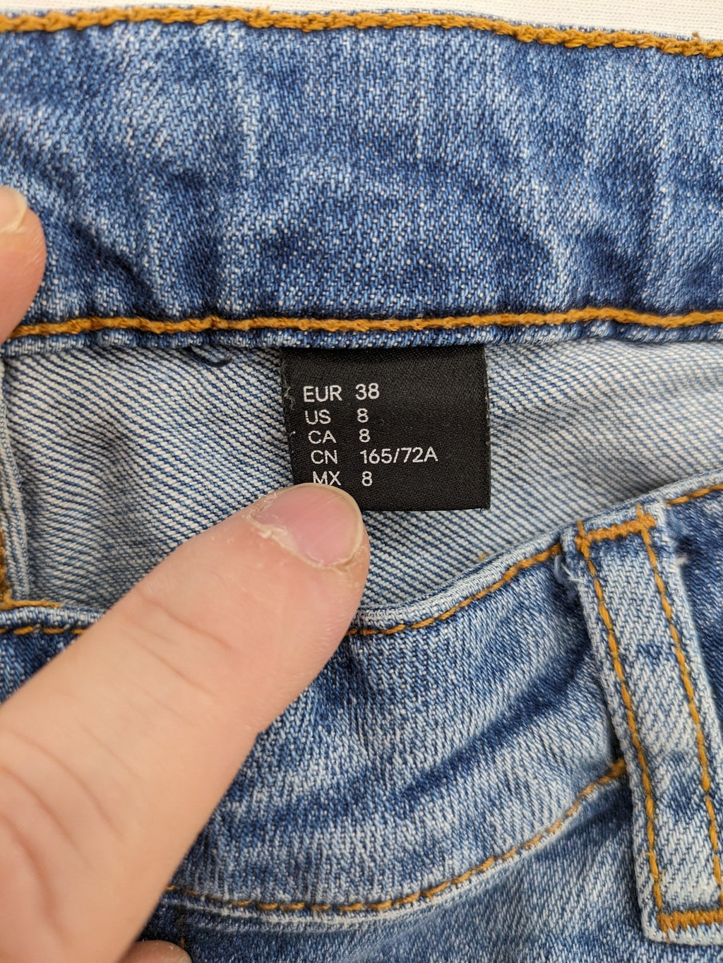 Denim blue distressed jeans shorts with frayed edges and a trendy used look.