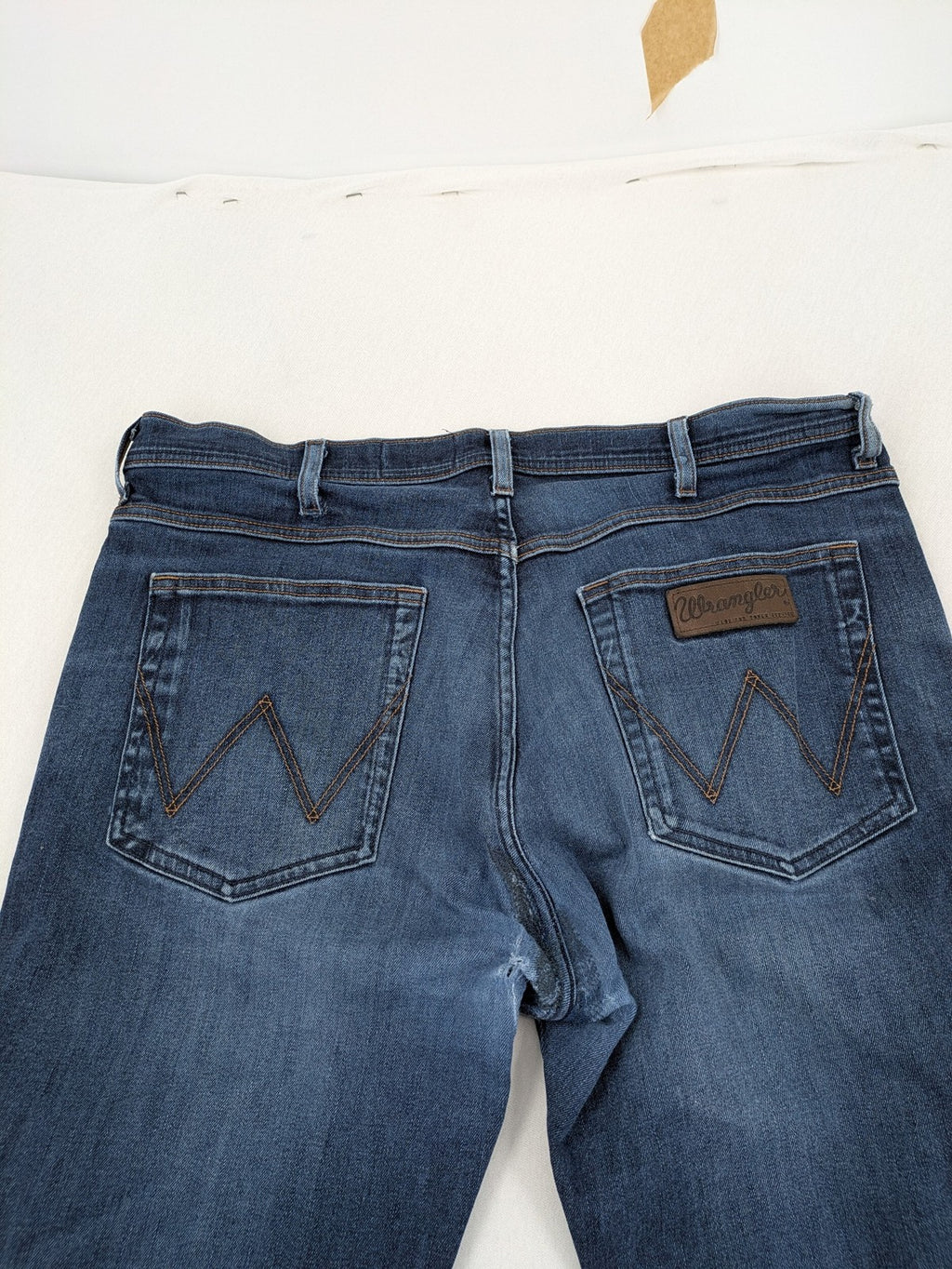 Wrangler straight jeans blue with iconic "W" stitching on back pockets.