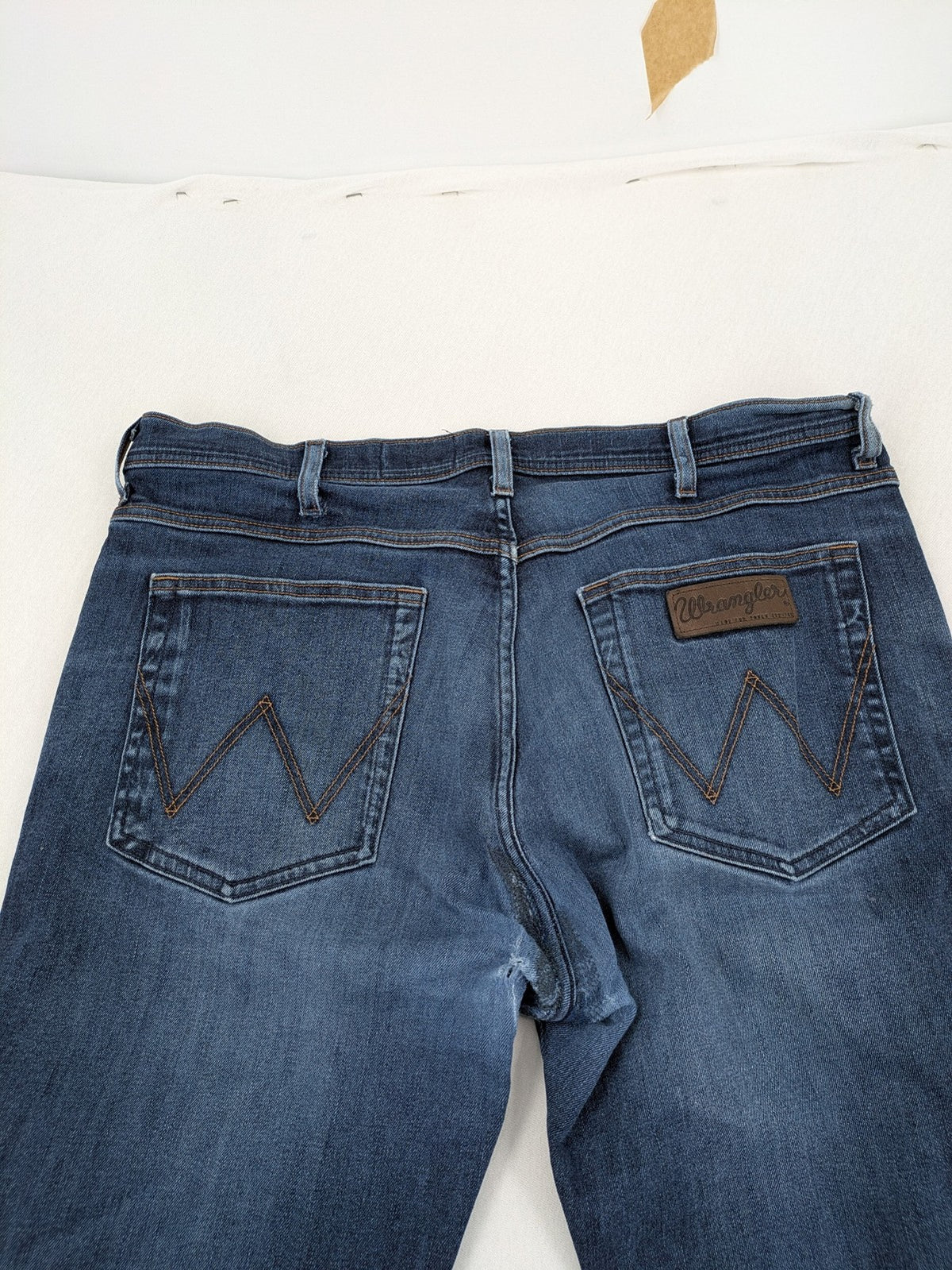 Wrangler straight jeans blue with iconic "W" stitching on back pockets.