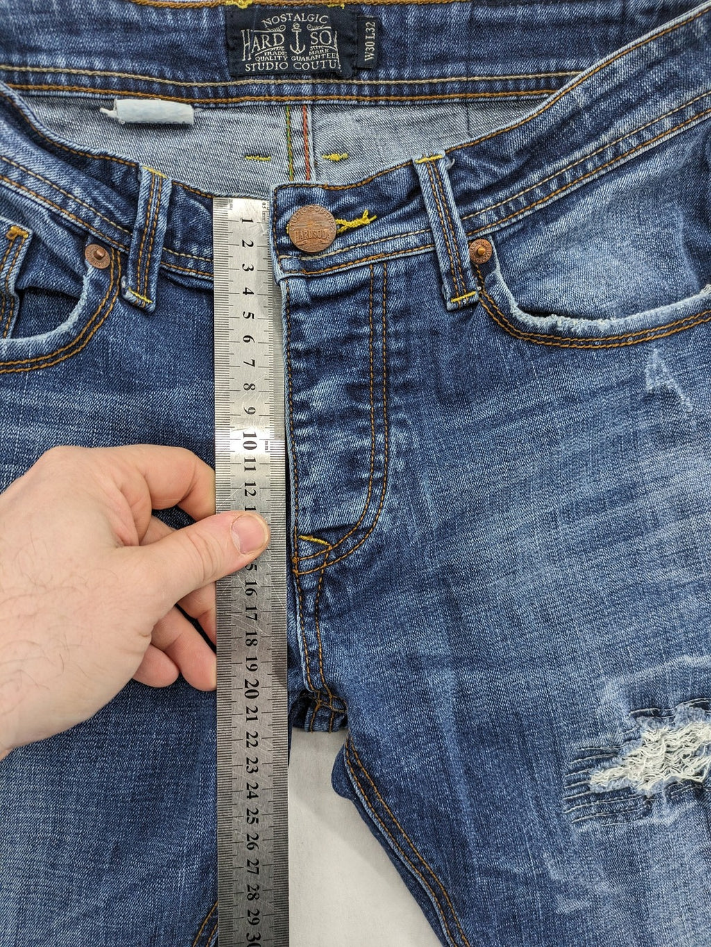 Soda blue straight jeans with distressed rips and button fly, cotton blend material.