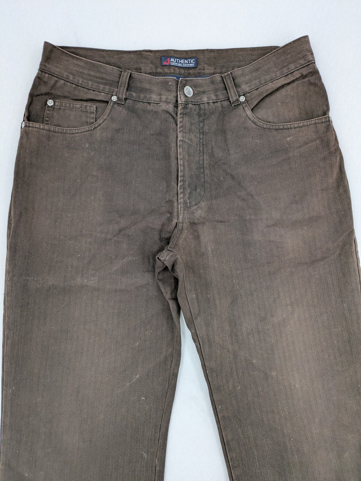 Authentic Clothing Company brown straight jeans with subtle stripe pattern and brand patch.