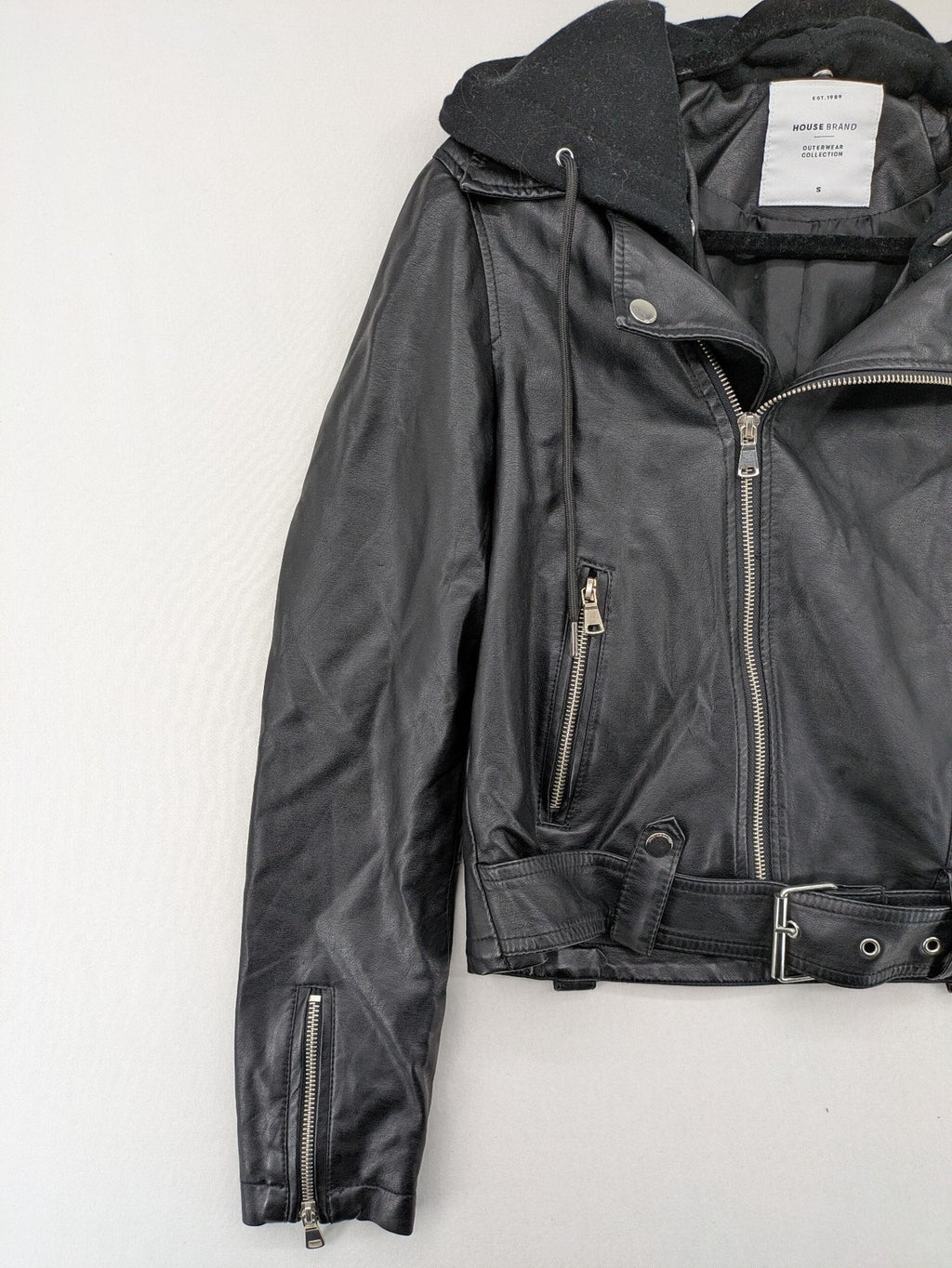 House Brand black biker jacket with hood, asymmetrical zipper, and belt detail.