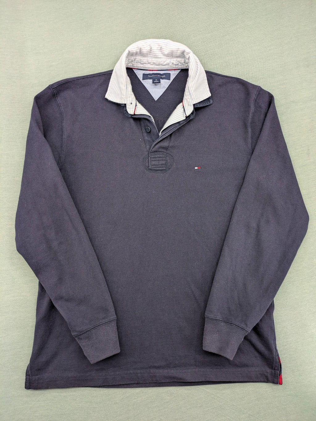 Tommy Hilfiger grey rugby polo shirt with navy striped collar and large H logo.