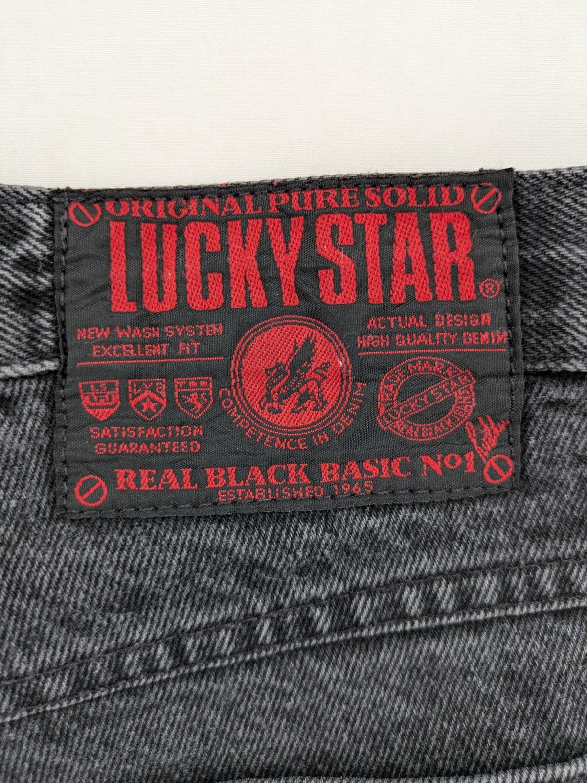 Lucky Star grey tapered high waist jeans with faded wash and red logo details.