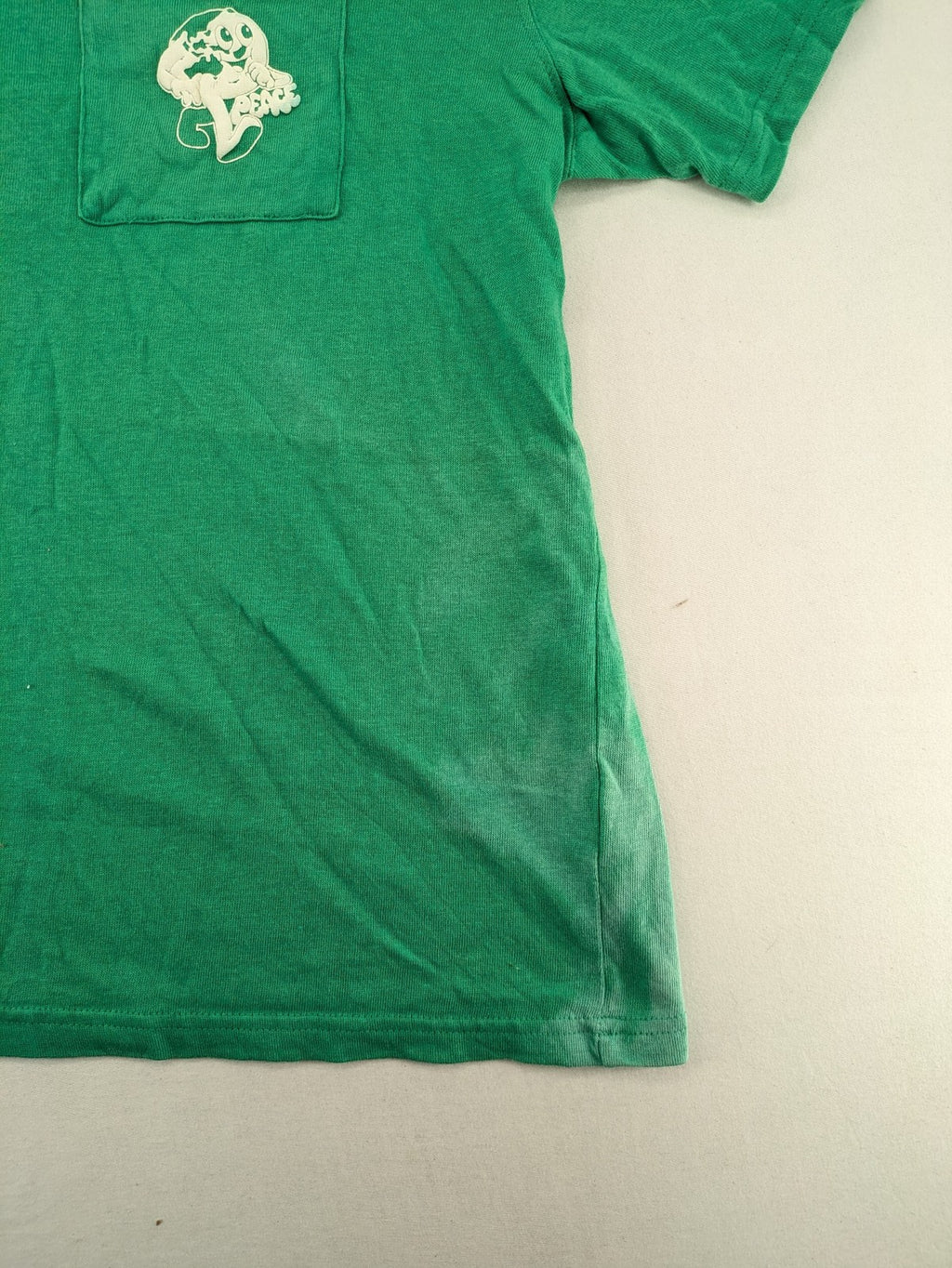 Myla green graphic t-shirt with large peace earth print and front pocket design.