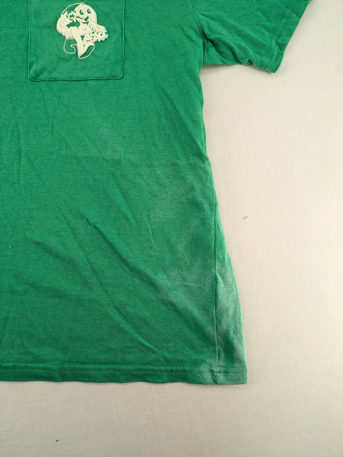 Myla green graphic t-shirt with large peace earth print and front pocket design.