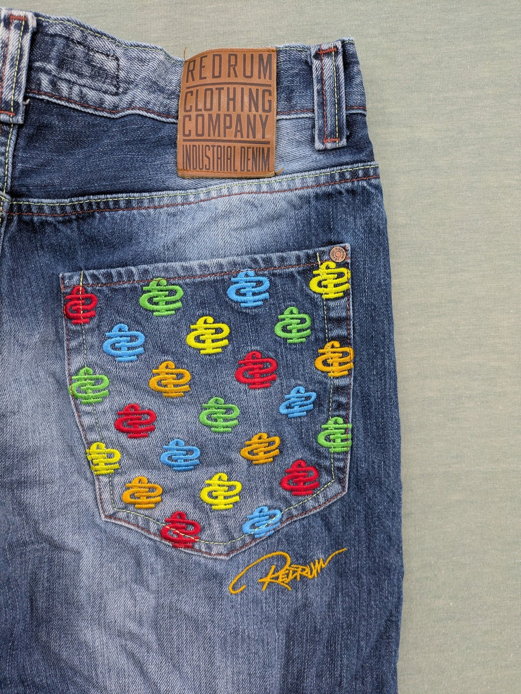 Y2K blue straight jeans with colorful logo embroidery and baggy fit.