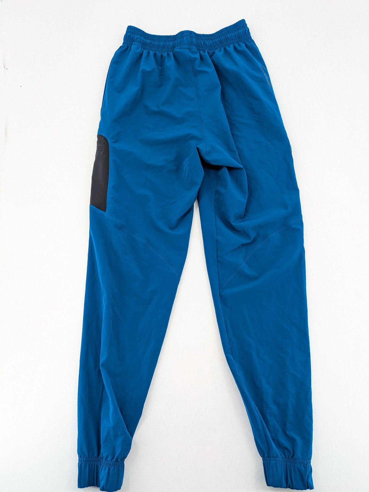 Under Armour blue HeatGear joggers with black accents and zippered cargo pockets.