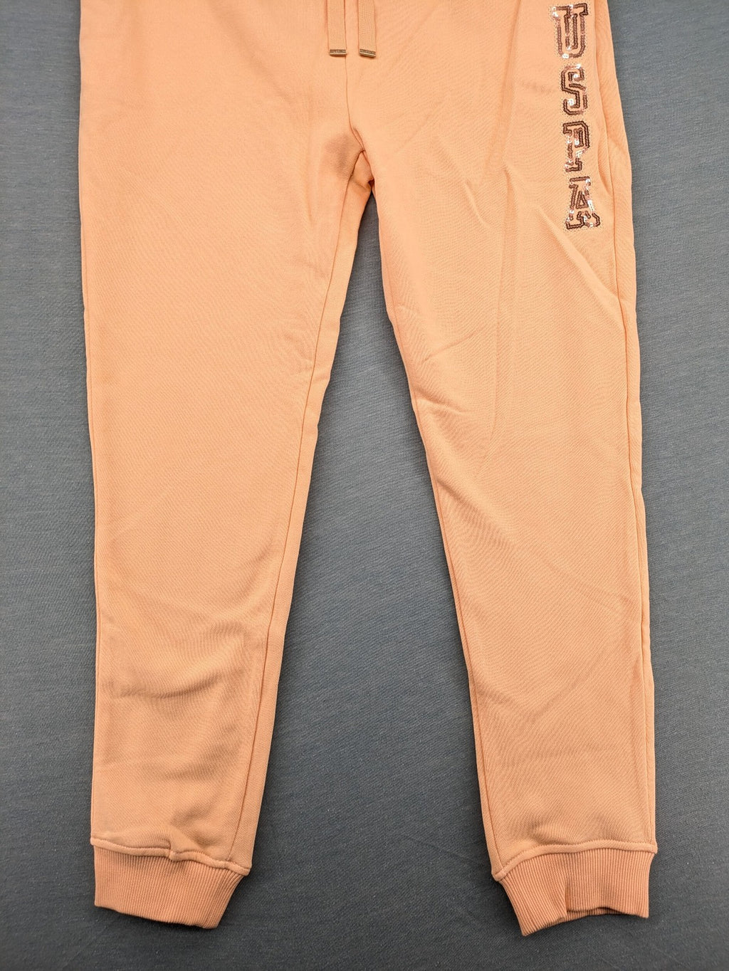 U.S. Polo Assn. orange sweatpants slim fit with sequin USPA logo on leg.