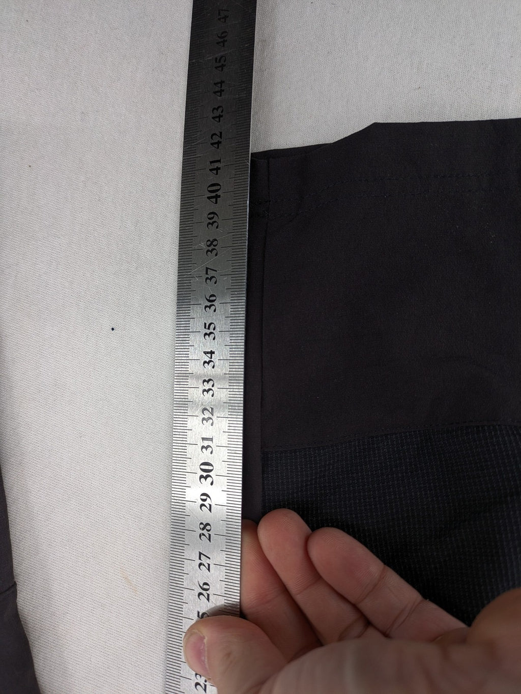 Outdoor black capri pants with elastic waistband and multiple zippered pockets.