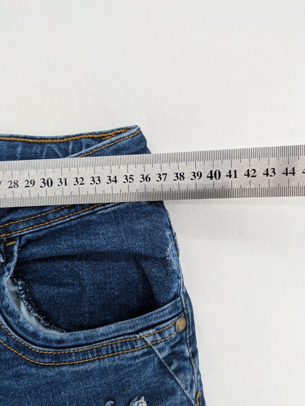 Denim & Co. blue skinny jeans with distressed ripped details and adjustable waistband.