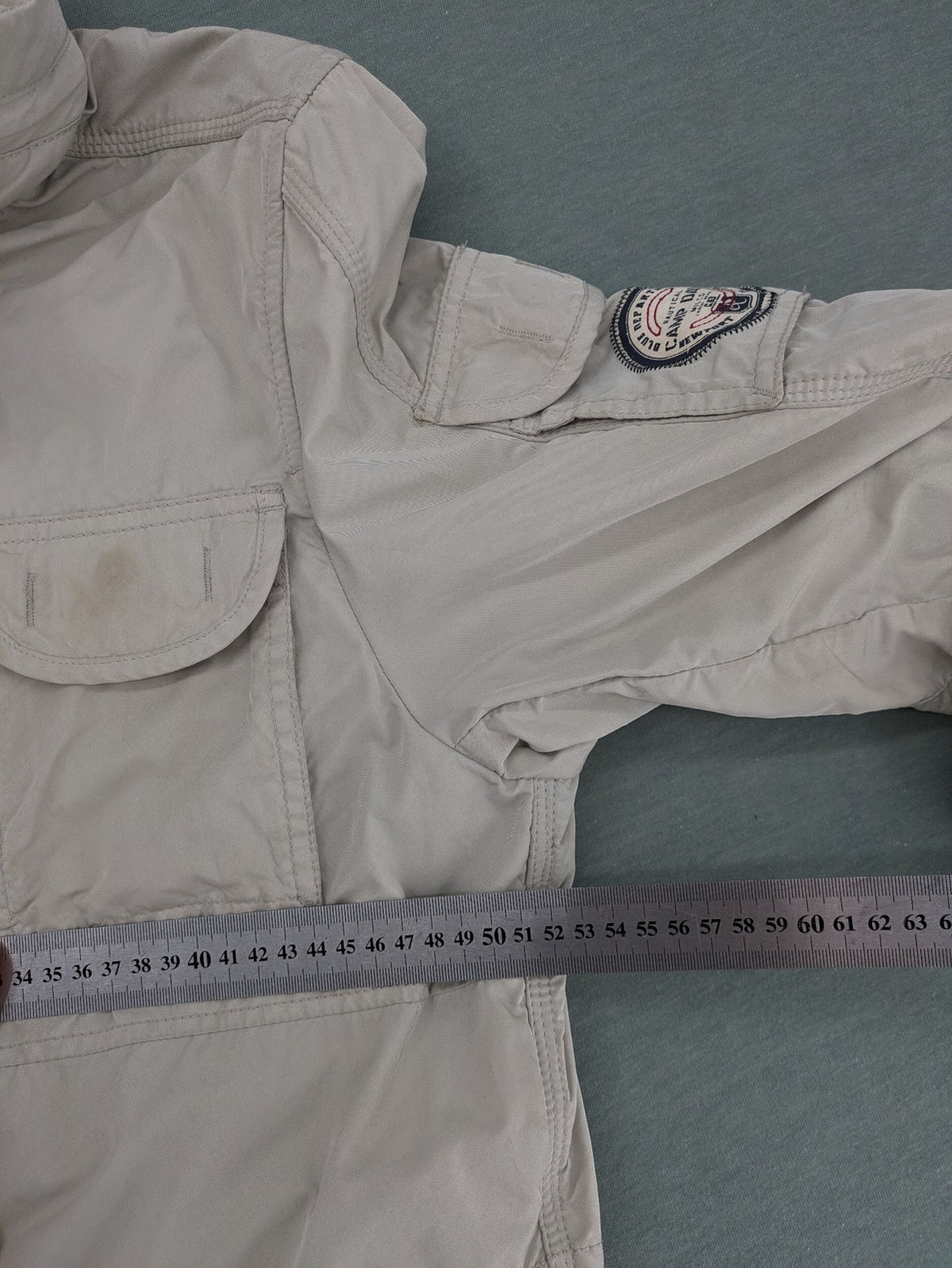 Camp David beige field jacket with logo patches, standing collar, and multiple pockets.