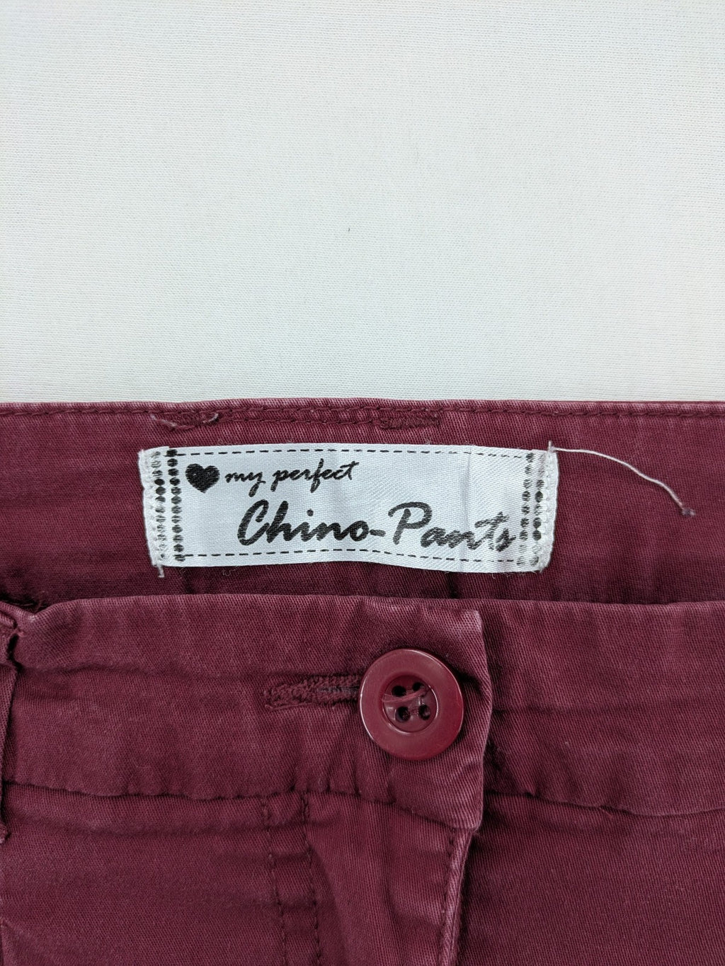 BPC Bonprix burgundy chino pants with front pleats and floral pocket lining.