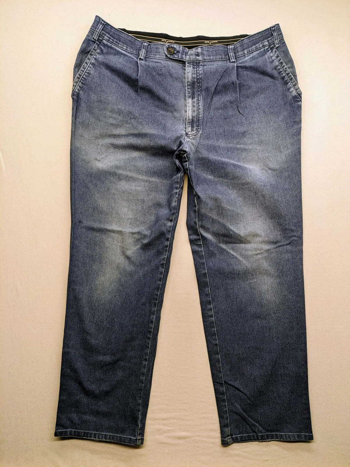 REI blue straight jeans with front pleats, zip fly, and buttoned back pockets.