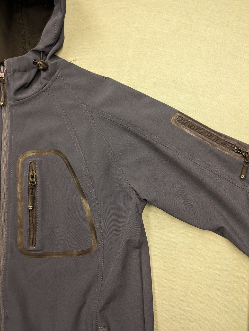 Life Line grey softshell jacket with adjustable hood and durable wind-resistant material.