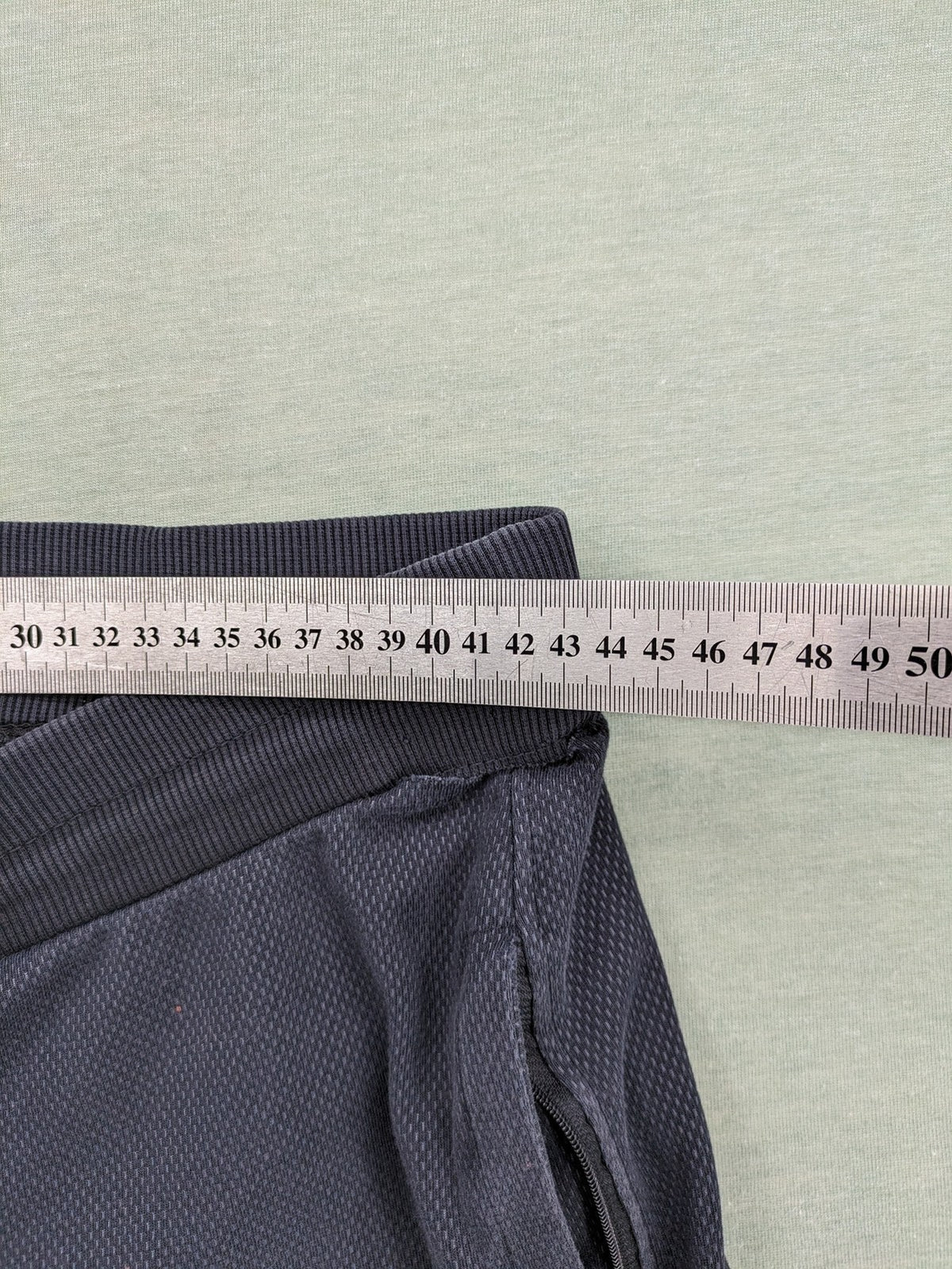Nike F.C. grey jogger pants with elastic waistband, side pockets, and embroidered Swoosh logo.