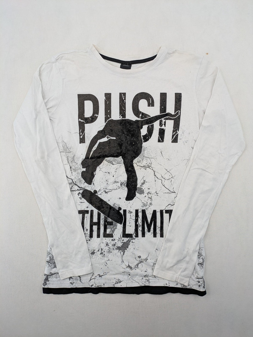 Chapter Young long sleeve shirt white with black skateboarder graphic and motivational text.