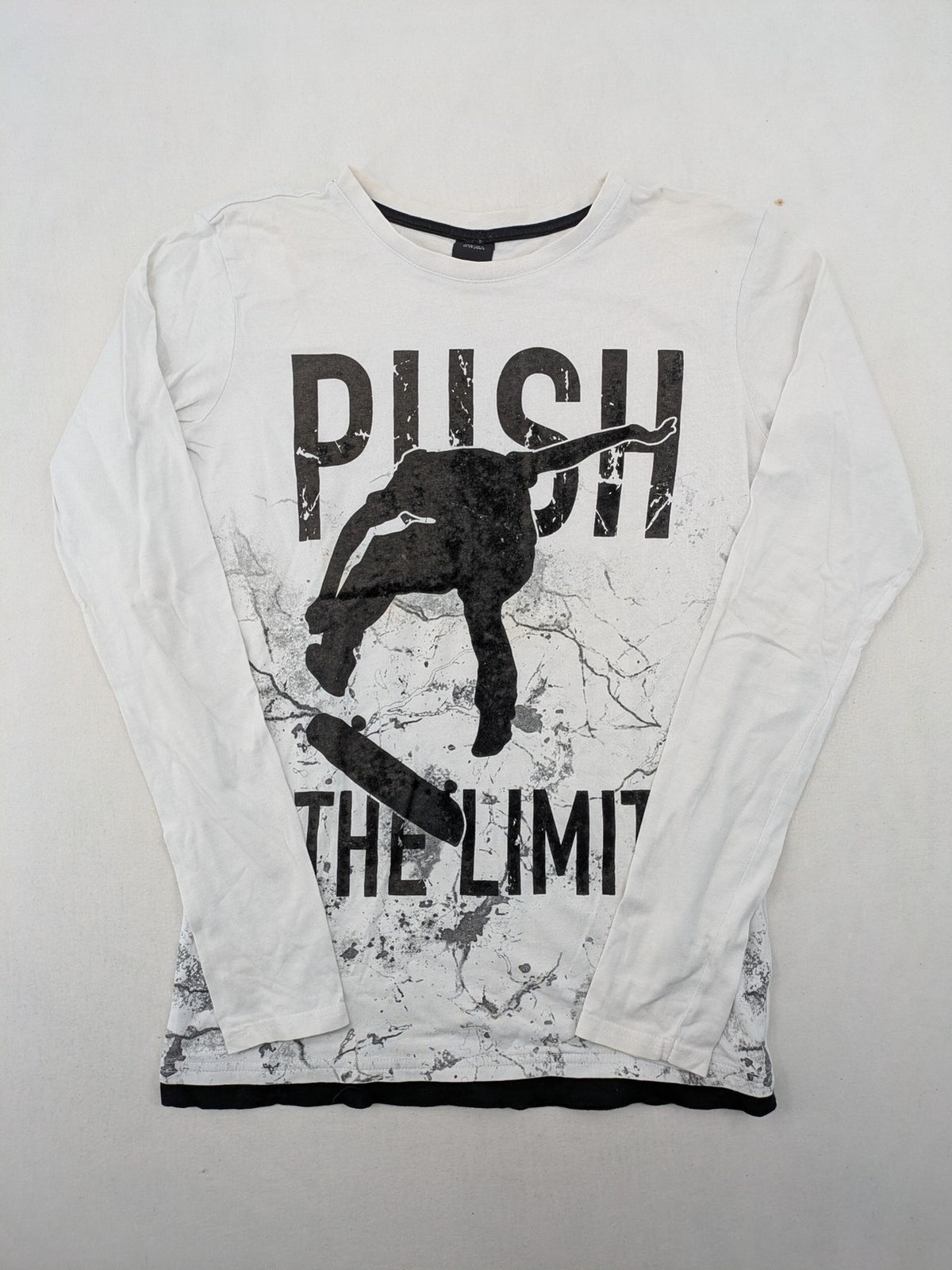 Chapter Young long sleeve shirt white with black skateboarder graphic and motivational text.