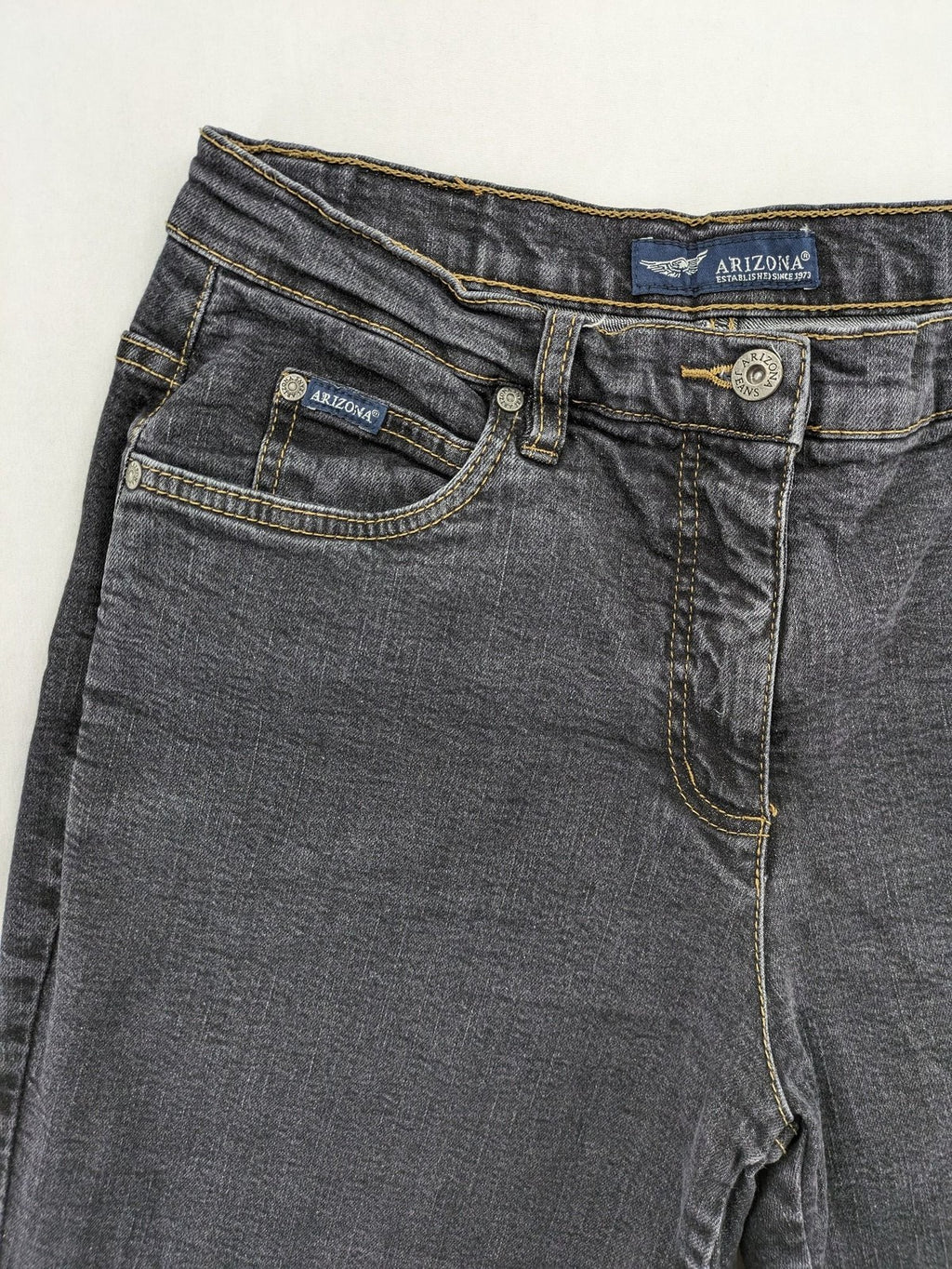 Bootcut grey low rise bootcut jeans five-pocket design with zipper and button closure.