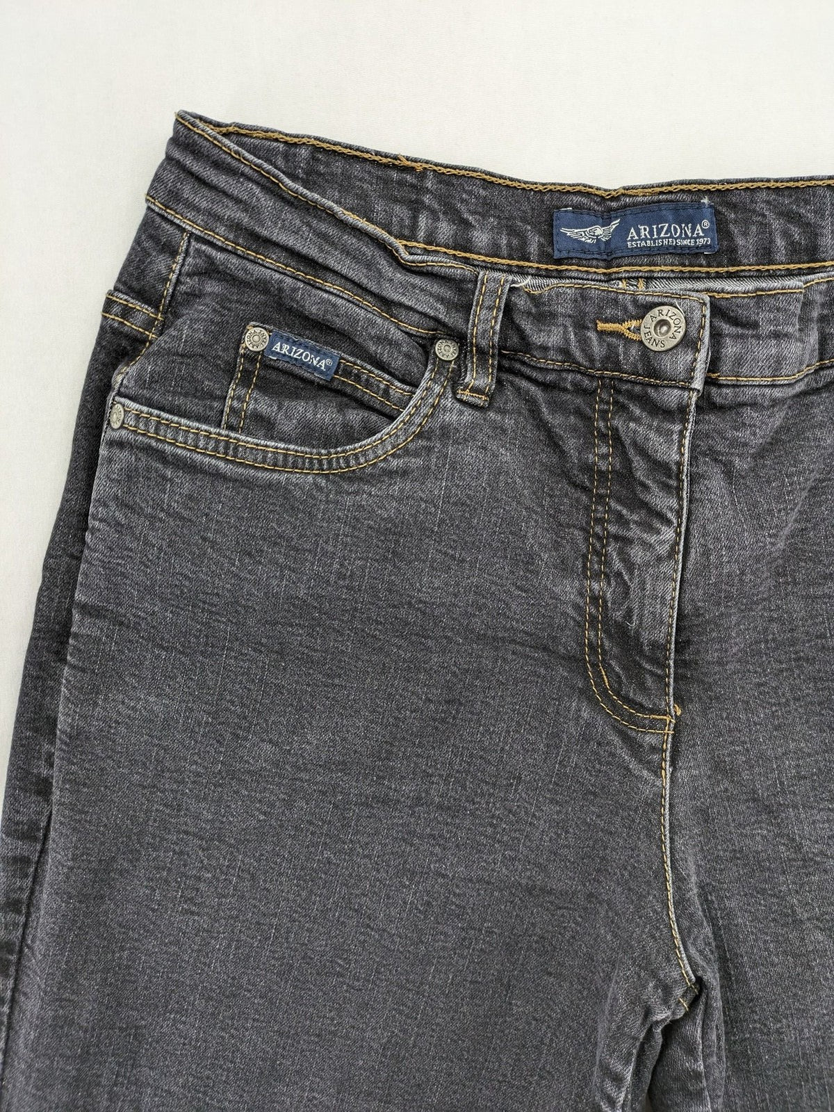 Bootcut grey low rise bootcut jeans five-pocket design with zipper and button closure.