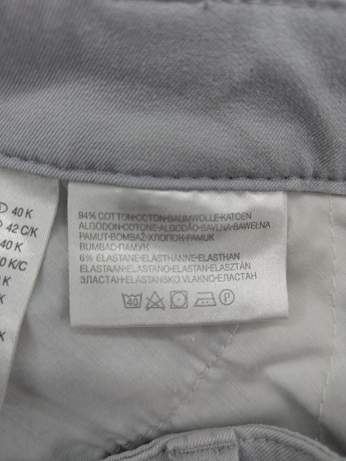 Chino grey capri pants five-pocket design with subtle embroidery and stretch cotton blend.