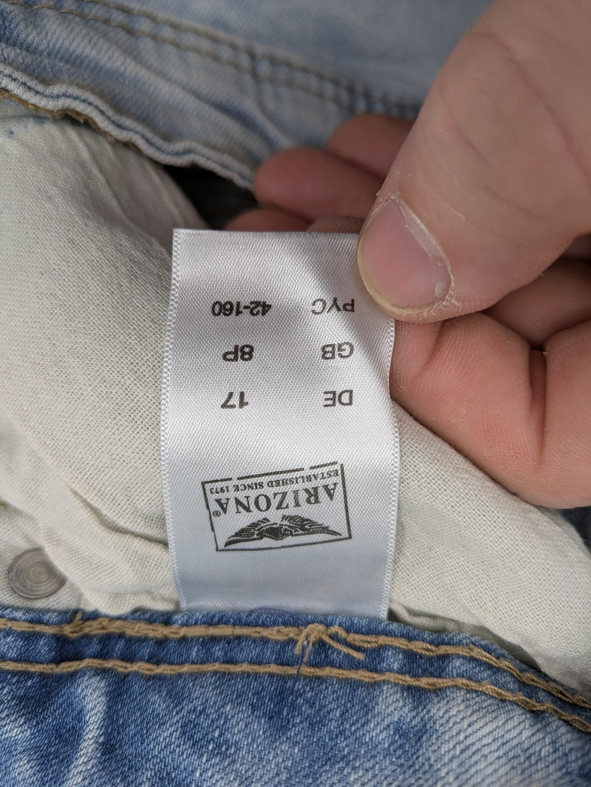 Arizona blue flare jeans with acid wash, button fly, and stretch denim material.