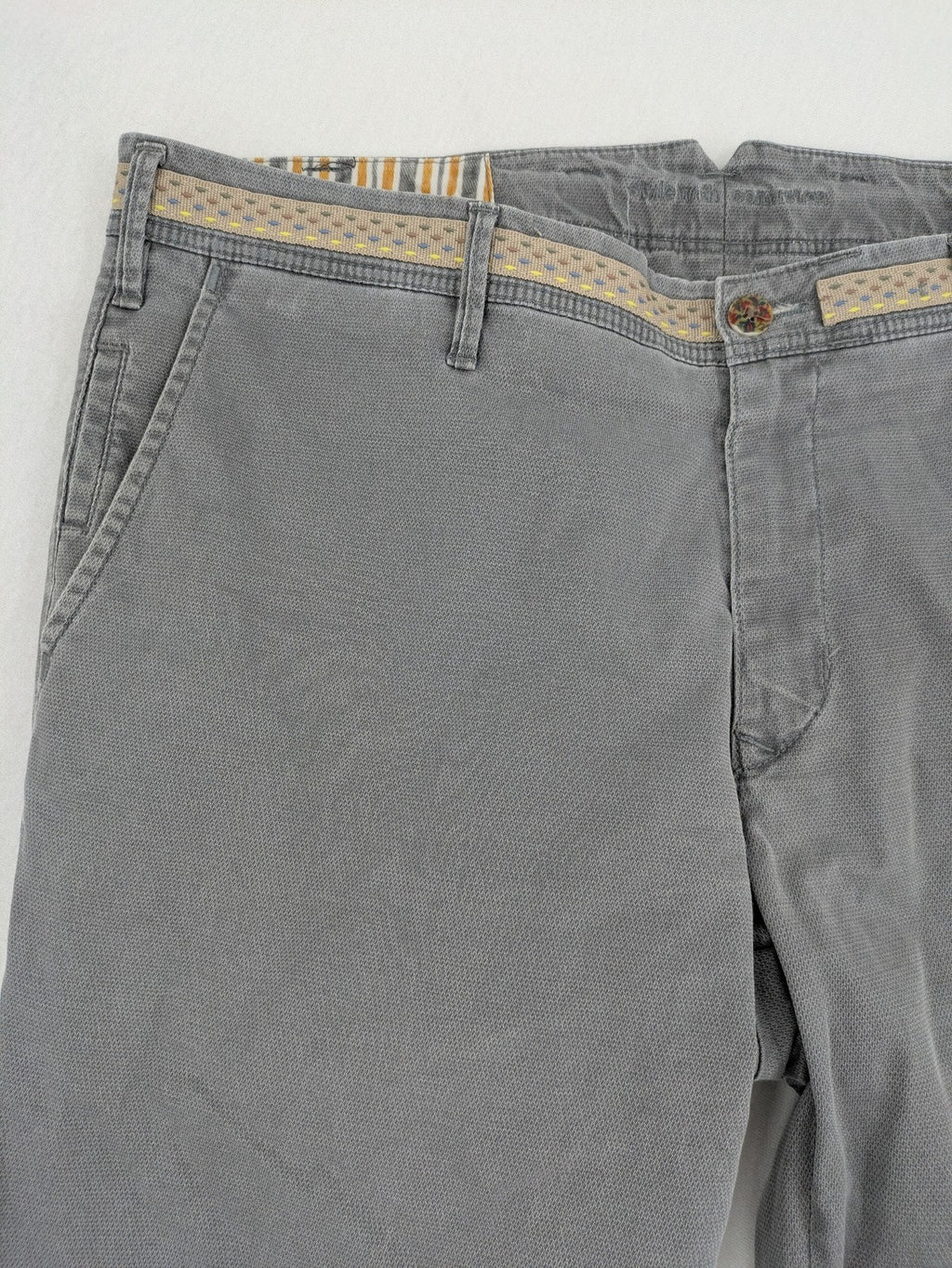 MMX grey chino pants with patterned interior lining and contrasting waistband, made from organic cotton.