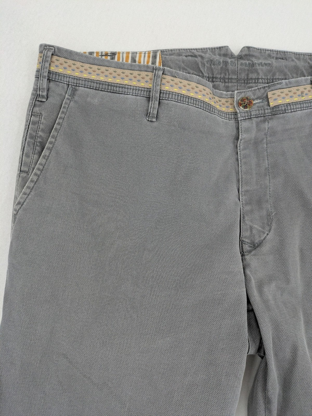 MMX grey chino pants with patterned interior lining and contrasting waistband, made from organic cotton.