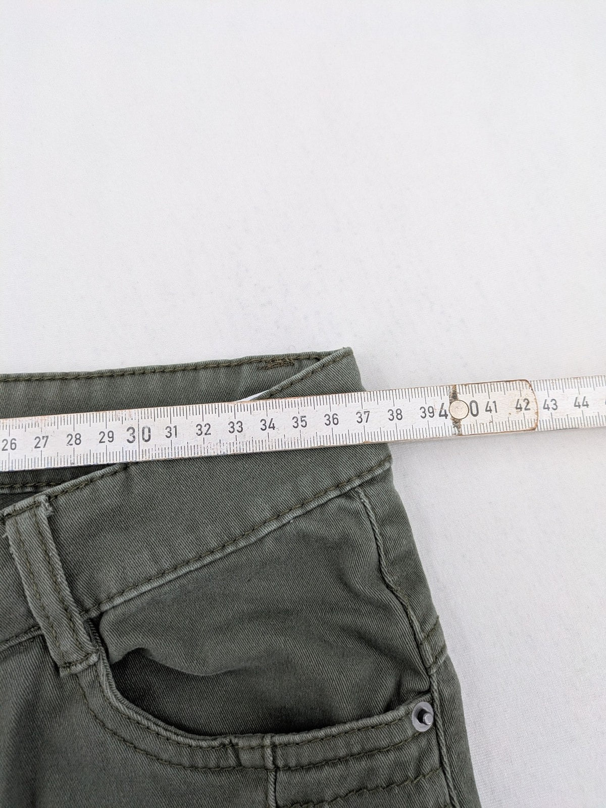 Page One Young khaki motorcycle pants with stitched panels and decorative zipper details.