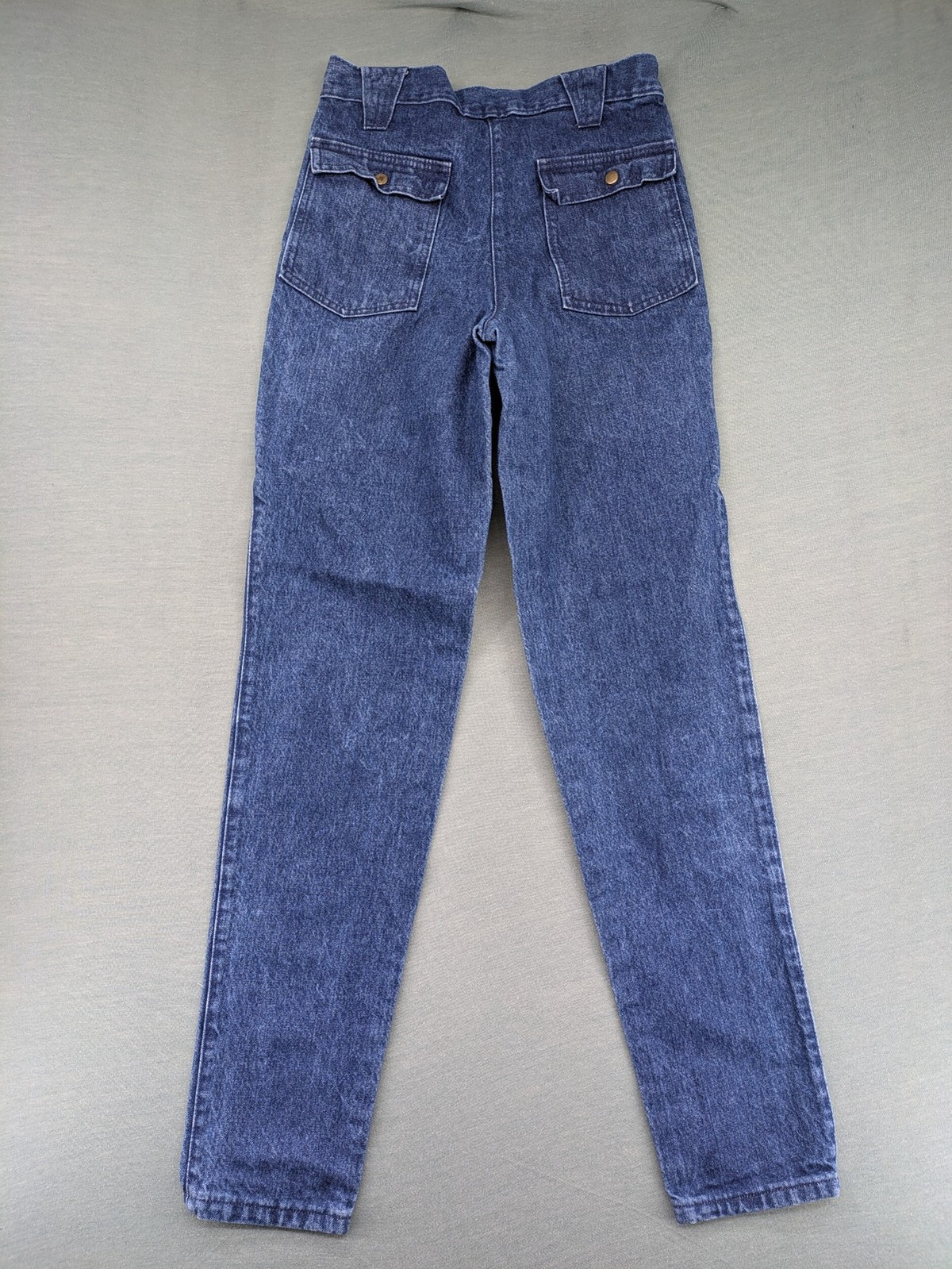 YKK blue high waist mom jeans with decorative front zipper pockets and vintage denim texture.