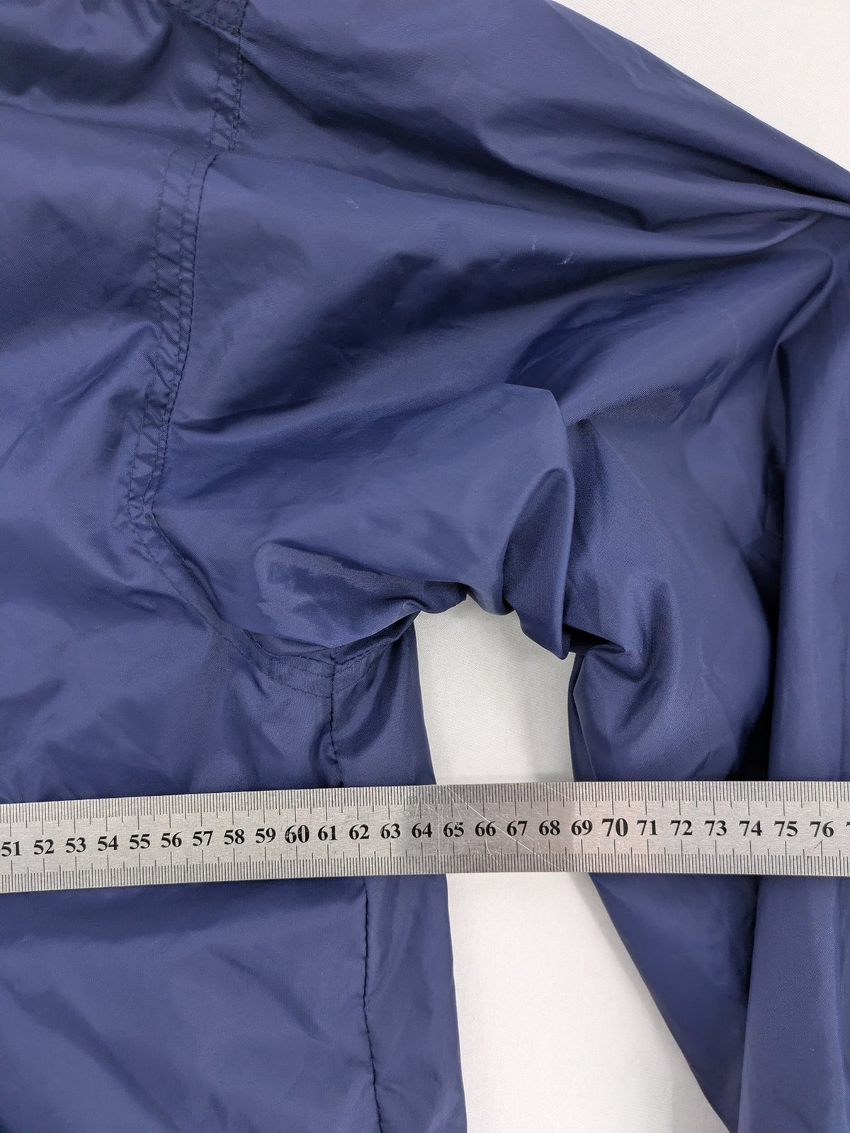Fila navy windbreaker jacket with large embroidered logo on chest and back.