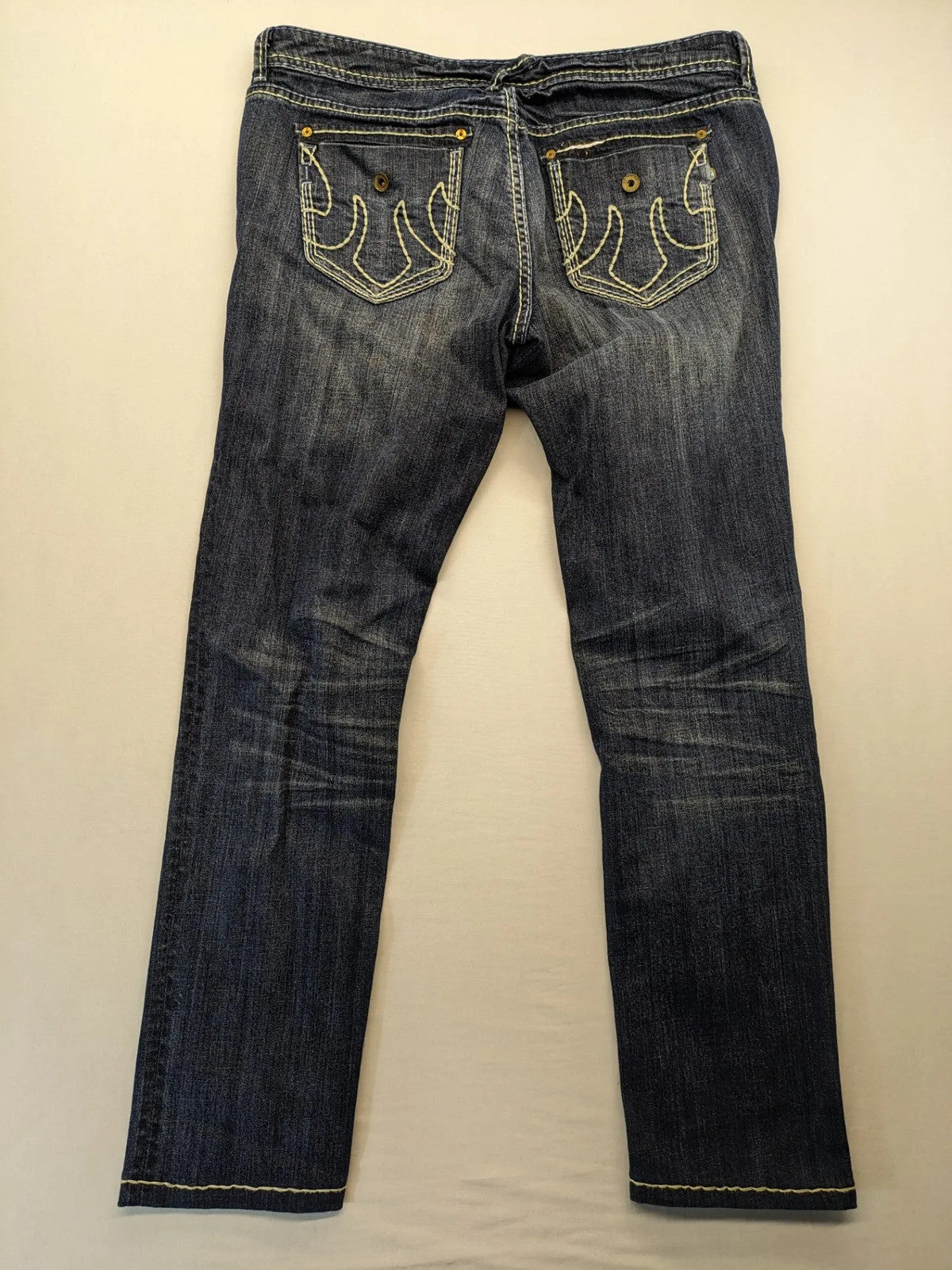 Rhodes blue skinny jeans with decorative studs and intricate embroidery on back pockets.