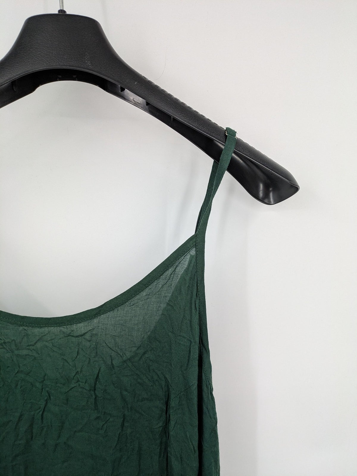 Boho green maxi dress with floral embroidery along tiered hem and adjustable spaghetti straps.