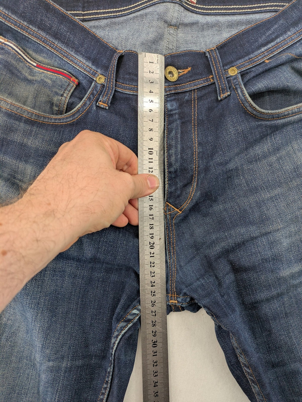 Tommy Hilfiger Denim blue straight jeans with five-pocket design and natural fading details.