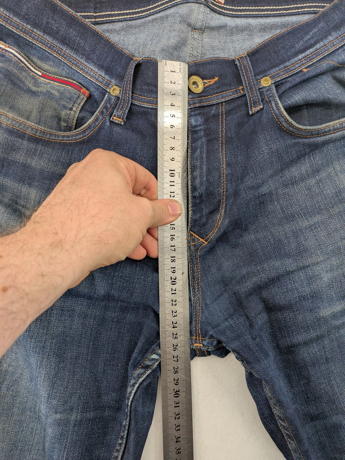 Tommy Hilfiger Denim blue straight jeans with five-pocket design and natural fading details.