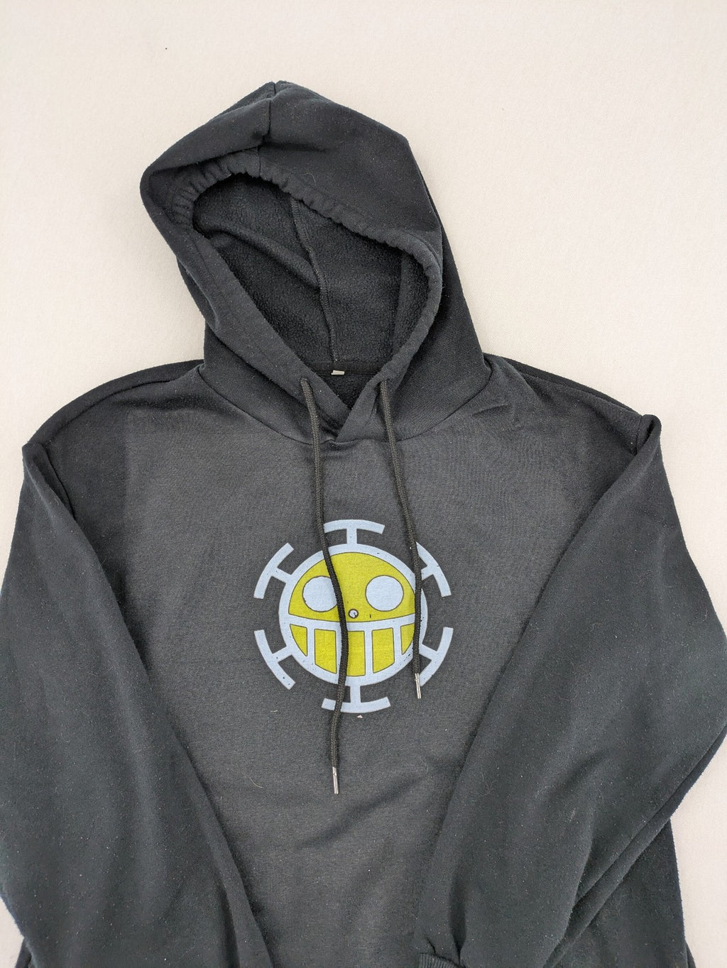 One Piece long hoodie black featuring Trafalgar Law's Jolly-Roger logo and drawstring hood.