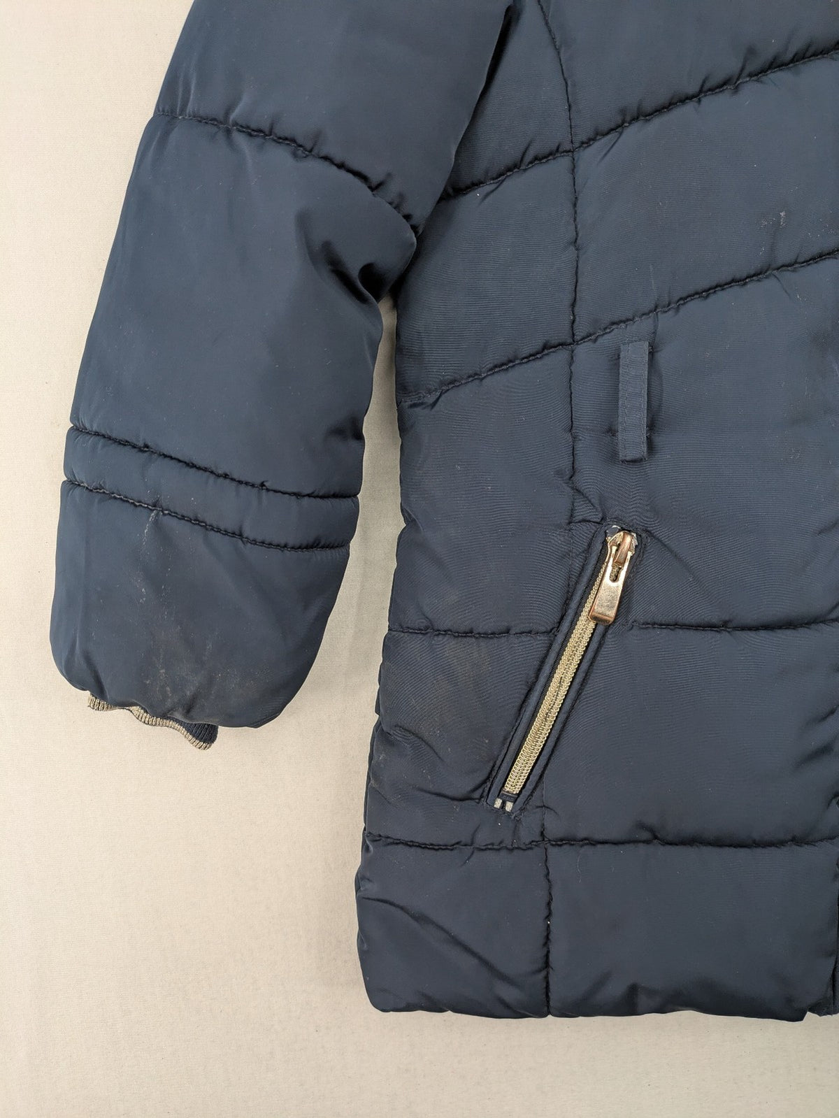 GEF cream coat with quilted design, fleece-lined hood, and faux fur trim.