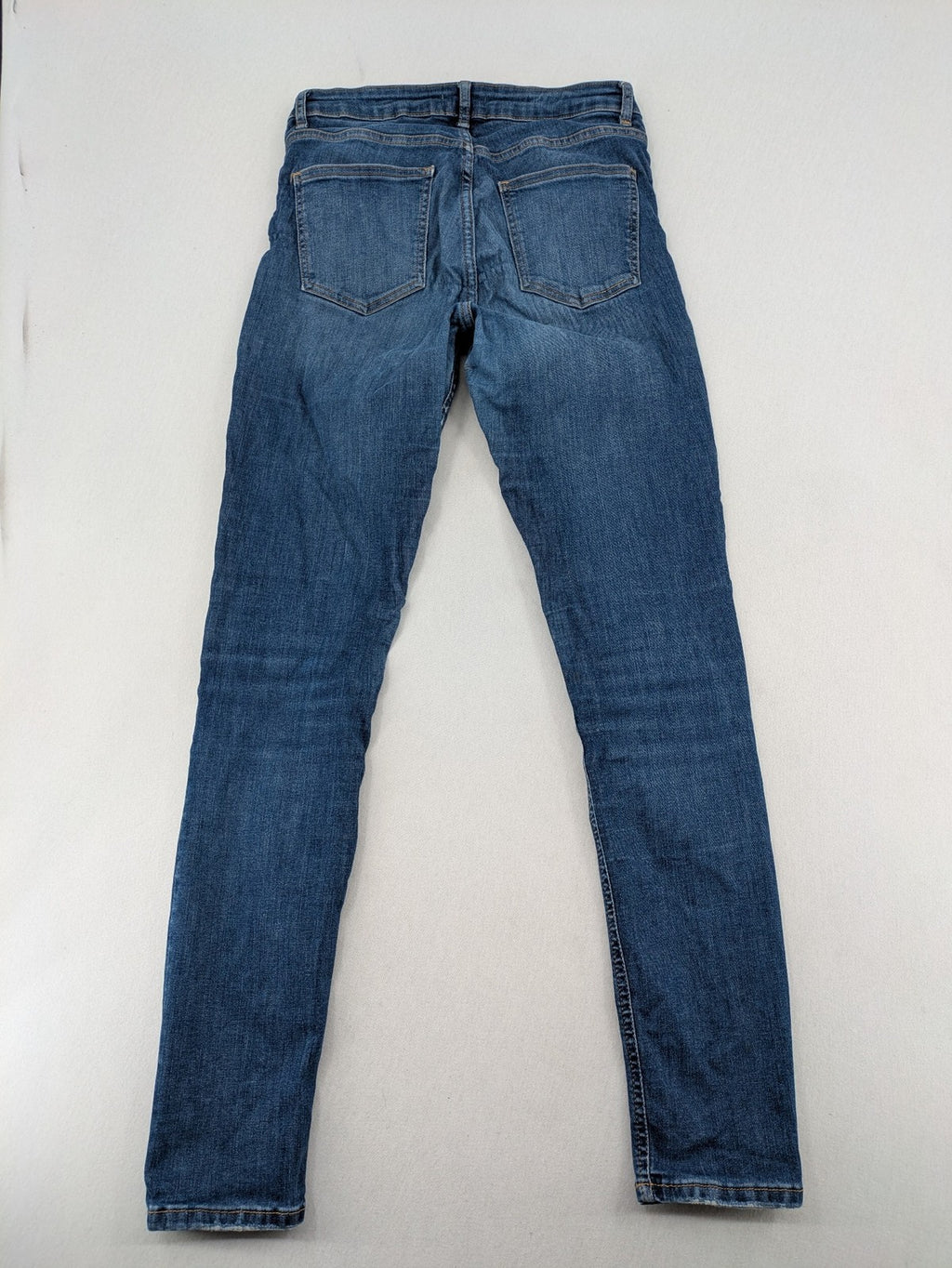H&M blue skinny jeans with distressed details and comfortable stretch denim material.