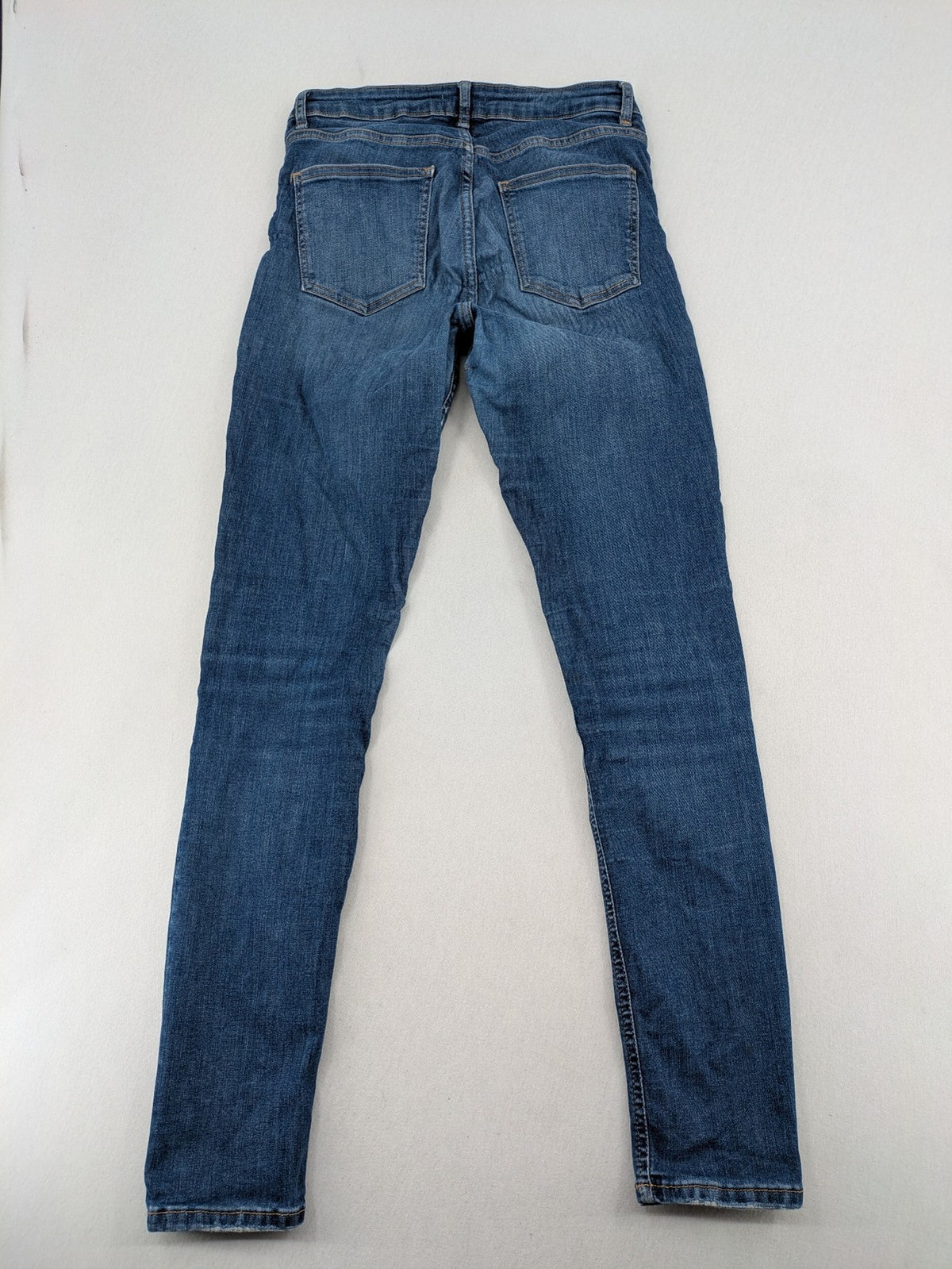 H&M blue skinny jeans with distressed details and comfortable stretch denim material.