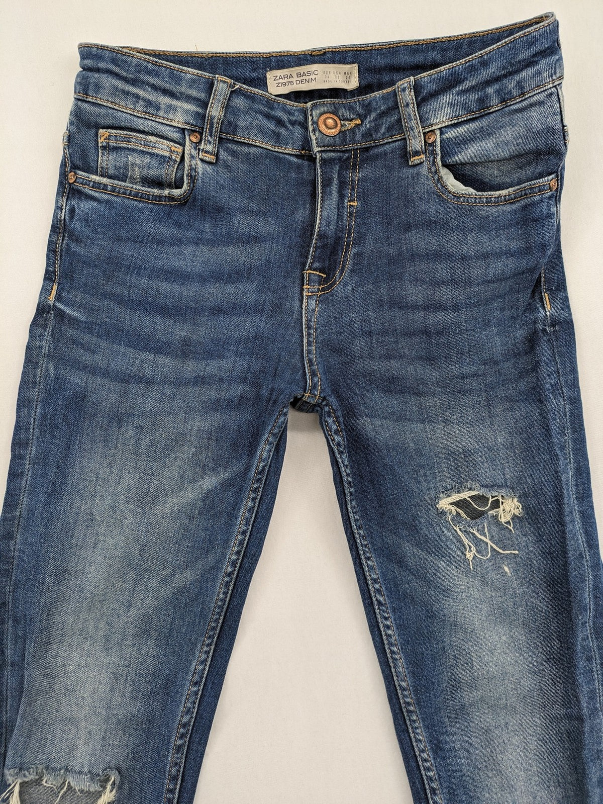 Zara Basic blue skinny jeans with destroyed knee details and frayed hem.
