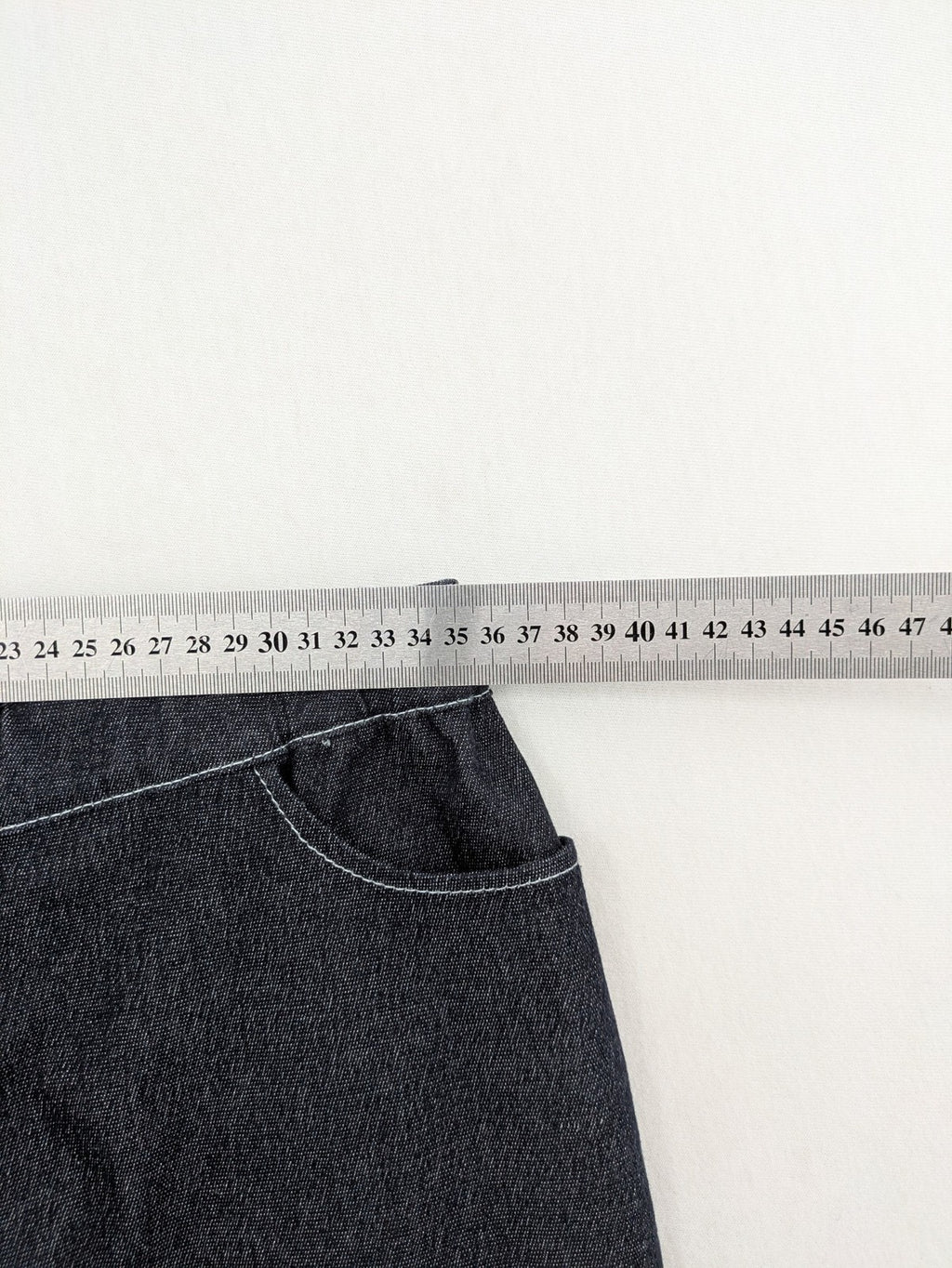 Extyn blue midi skirt with rhinestone dragonfly detail and front slit, stretchy denim fabric.