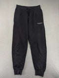 McKenzie black joggers with white logo, tapered fit, and ribbed ankle cuffs.
