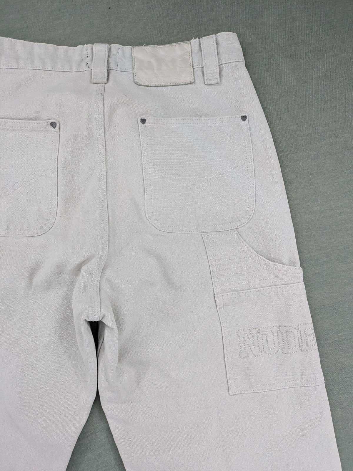 NUDE beige pants with double knee reinforcements and multiple utility pockets.