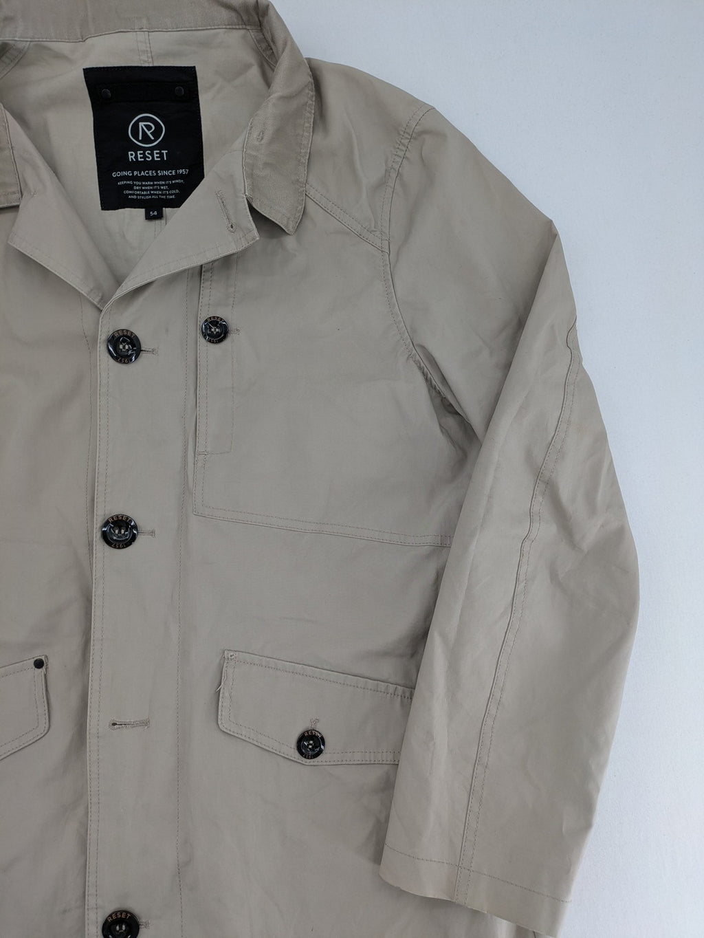 ReSET beige coat with contrasting dark blue lining and classic design details.