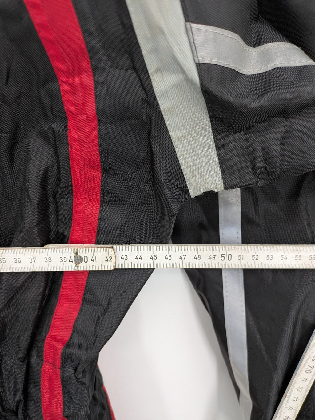 Unitech black rain suit with red reflective stripes and full zipper, size M.