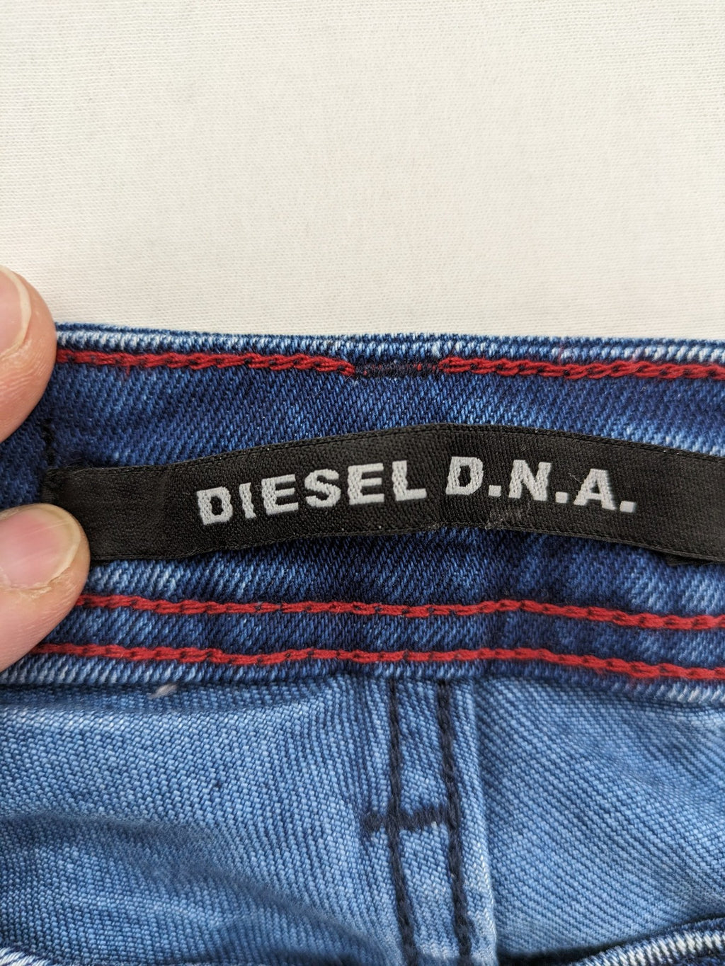 Diesel blue straight jeans with distressed details and ripped accents, made of cotton.