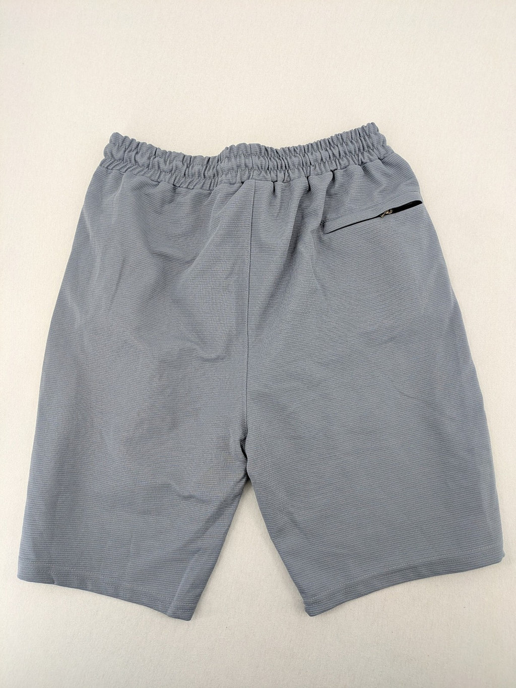 Nike grey shorts with Dri-FIT technology, elastic waistband, and zippered pockets.