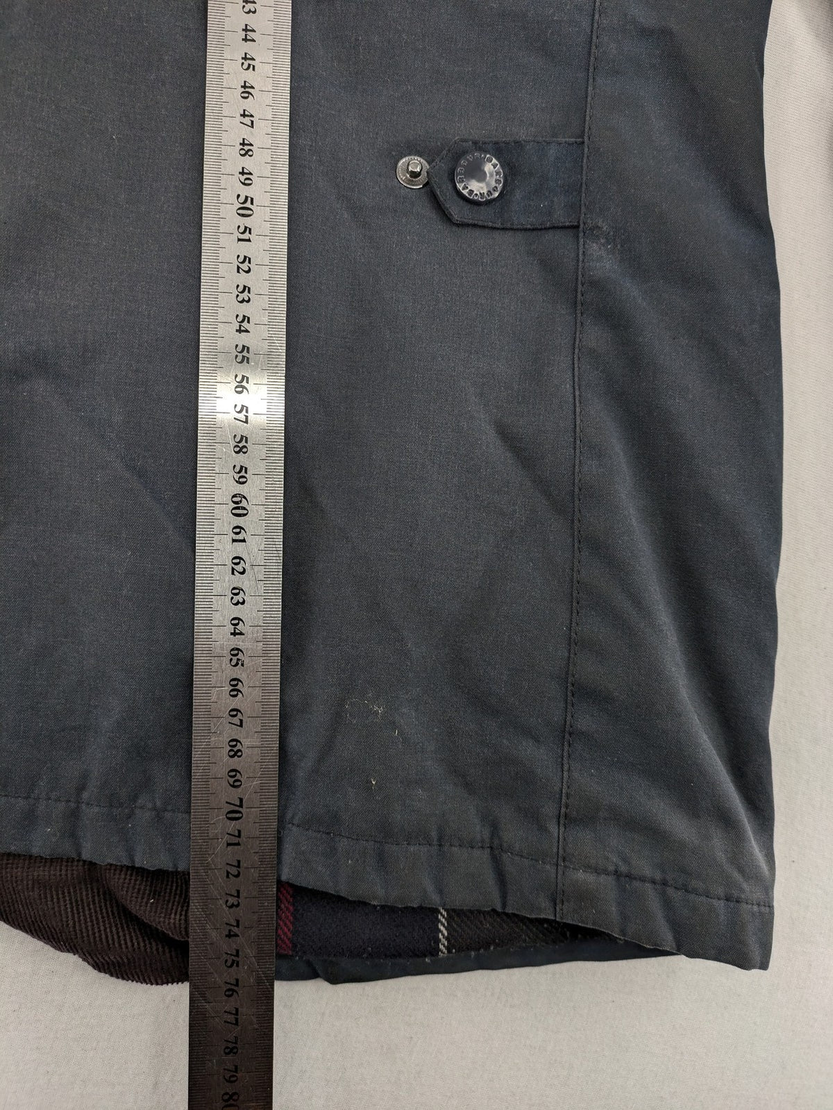Barbour navy wax jacket with quilted lining and leather elbow patches, tartan interior.