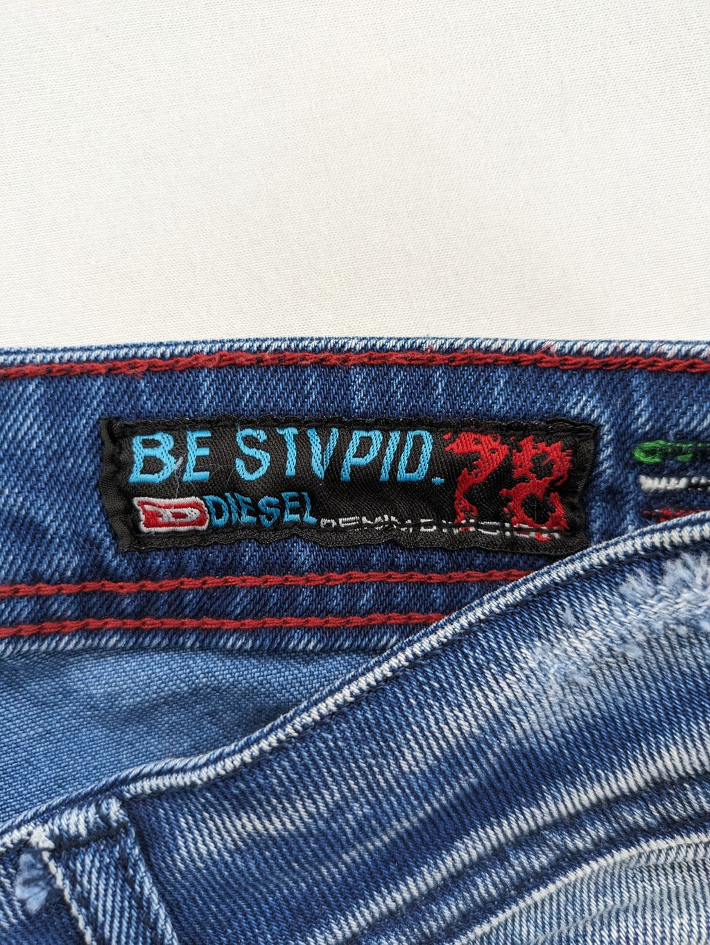 Diesel blue straight jeans with distressed details and ripped accents, made of cotton.