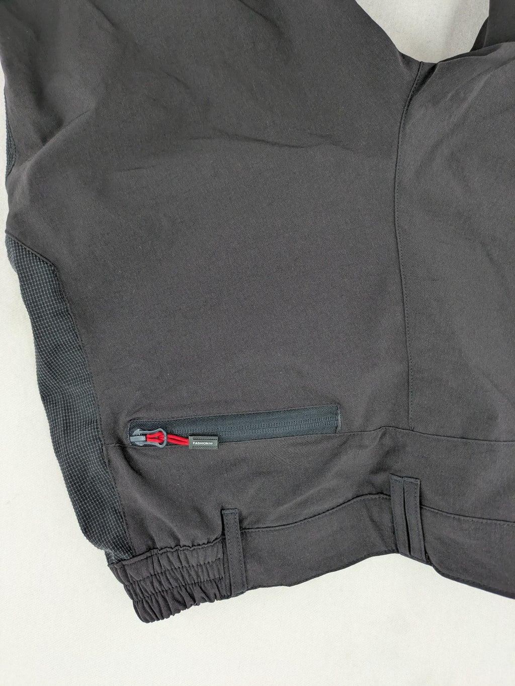 Outdoor black capri pants with elastic waistband and multiple zippered pockets.
